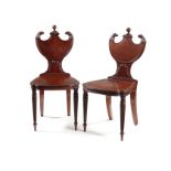 A pair of Regency mahogany carved hall chairs attributed to Gillows