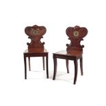 A pair of late Regency carved mahogany hall chairs