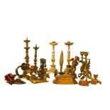 A group of brass and gilt metal candlesticks and decorative objects, mostly 19th century