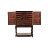 A 17th century Dutch oak and purpleheart cabinet on later stand