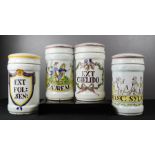 A set of four Italian ceramic apothecary jars, painted with detail.