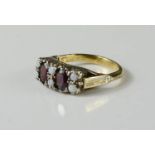 A 9ct gold and silver ring set with garnets and opals, size N, 3.5g.