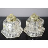 A pair of antique brass and glass inkwells.