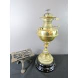 A brass Victorian paraffin lamp and an iron kettle stand.
