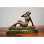 Bronze figure of a reclining woman, raised on a green marble plinth, 19cm high.