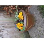 A group of terracotta plant pots and a stone planter with bulbs and flowers.