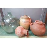 A large glass bottle / terrarium together with three large jars; two terracotta and one stoneware.