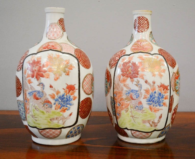 A pair of Chinese stoneware glazed bottle vases, painted with roundels and panels depicitng peacocks