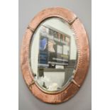 An Arts & Crafts copper oval mirror.