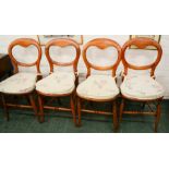 A set of four balloon back chairs with caned seats and padded cushions.