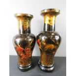 A pair of wooden black lacquered Chinese vases.
