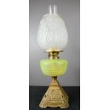 A Victorian oil lamp with vaseline glass bowl and pressed glass shade.