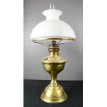 A Victorian oil lamp with white glass shade.