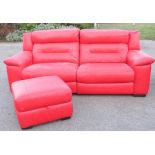 A red leather two seater settee with matching footstool, mechanical recliners.