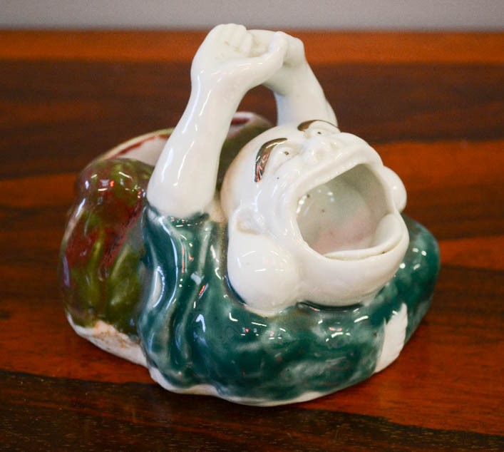 A Chinese porcelain humourous figure with gaping mouth, 10cm high.