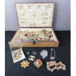 A quantity of costume jewellery in a wooden box.