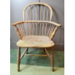 A 19th century Windsor armchair, with hoop back and bowed arm rail pierced with spindles, residual