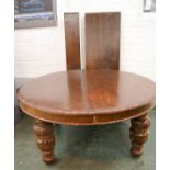 A 17th century style oak dining table, with two extra leaves, and large carved cup and cover legs,