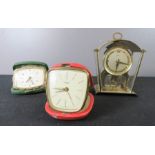 Two travelling alarm clocks and a brass mantle clock; Schatz 8 day.