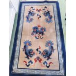 A cream ground rug, depicting blue Chinese dragons.