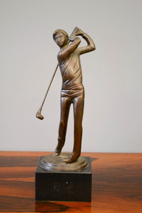 A bronze figure of a golfer, on a slate base, 34cm high.