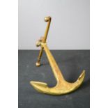 A brass desk ornament in the form of an anchor.