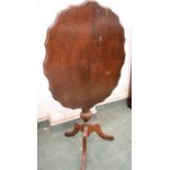 A mahogany tilt top tripod table, with shaped top.