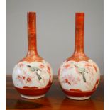 Two Chinese bottle vases with red ground and gilded highlights, depicting birds, 24cm high.