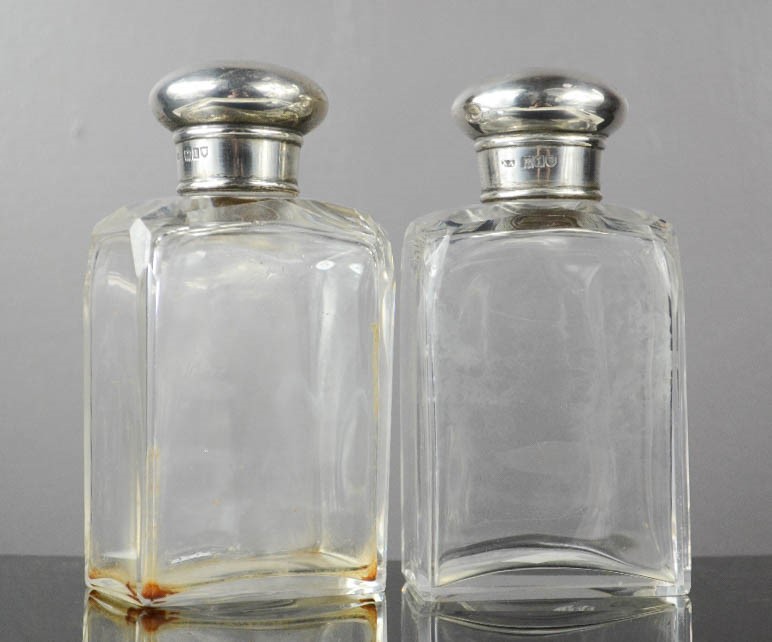 A pair of silver and glass dressing table bottles, London.