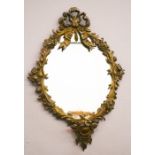 A French style bronzed metal wall mirror, oval form with bow cast to the top, 46 by 32cm.
