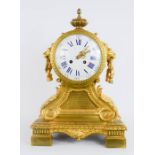 A French 19th century ormolu clock, with Roman Numeral enamel dial, lion head handles.