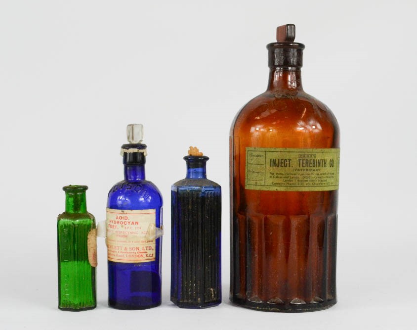 A group of antique coloured glass poison and medicine bottles.