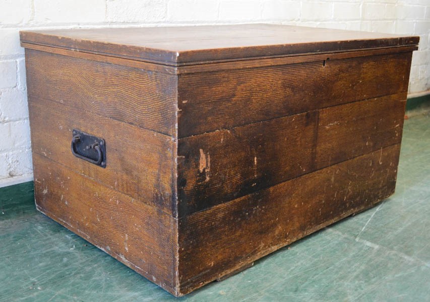 A pine blanket chest with painted faux patination and iron handles.