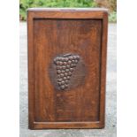 An oak linen box carved to the front with grapes; 64 by 40 by 28cm.