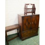 A two door cabinet, magazine rack and an oak table.