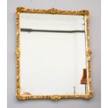 A gilt composition wall mirror, rectangular with carved border, 67 by 57cm