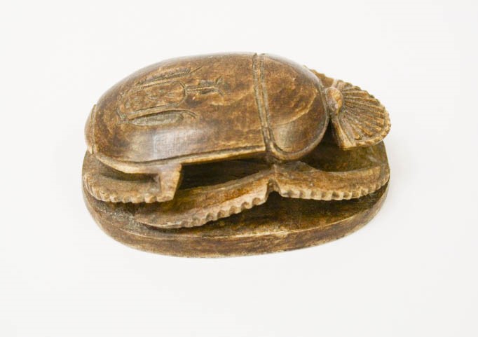 An Egyptian carving of a scarab beetle, with symbols to the underside, 8cm long.