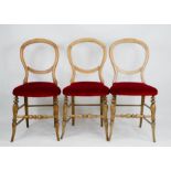 Three balloon back chairs with red velour upholstered seats.