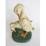 A cast iron door stop in the form of two ducks, painted with detail.