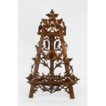 A Blackforest easel / book stand, intricately carved and pierced intertwining vine and leaves.