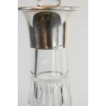 A crystal decanter with silver collar.