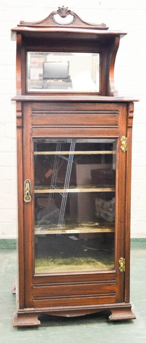 An Edwardian mahogany music cabinet, the upper section having a mirrored back, and glazed door