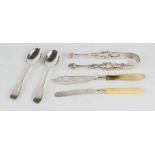 A pair of silver teaspoons, strapwork sugar tongs, butter knife and fruit knife.