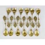 A set of twelve German white metal and gilt spoons, the decorative handles modelled with cherubs,