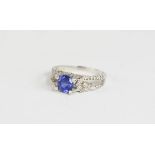 A 14k white gold, diamond and tanzanite brilliant cut ring, the split shank with diamonds, size N,