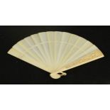 A 19th century ivory fan, carved with a floral group, 20cm high.