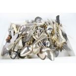 A large group of flatware, silver plated spoons, horn handled knives and other examples.