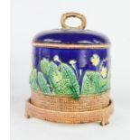 A majolica style Wedgwood cheese dish depicting yellow flowers, and basket weave base, 26cm high.