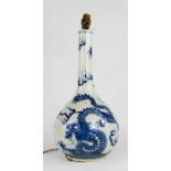 An early 19th century Chinese blue and white bottle vase, decorated with dragons, converted into a