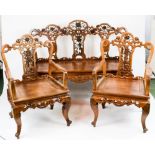 A 19th century Guan Kua Lee settee and chairs, with pierced floral carved decoration.